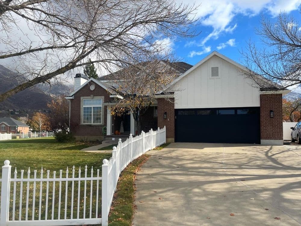 Charming single-family home with brick facade and white picket fence in a serene neighborhood.
