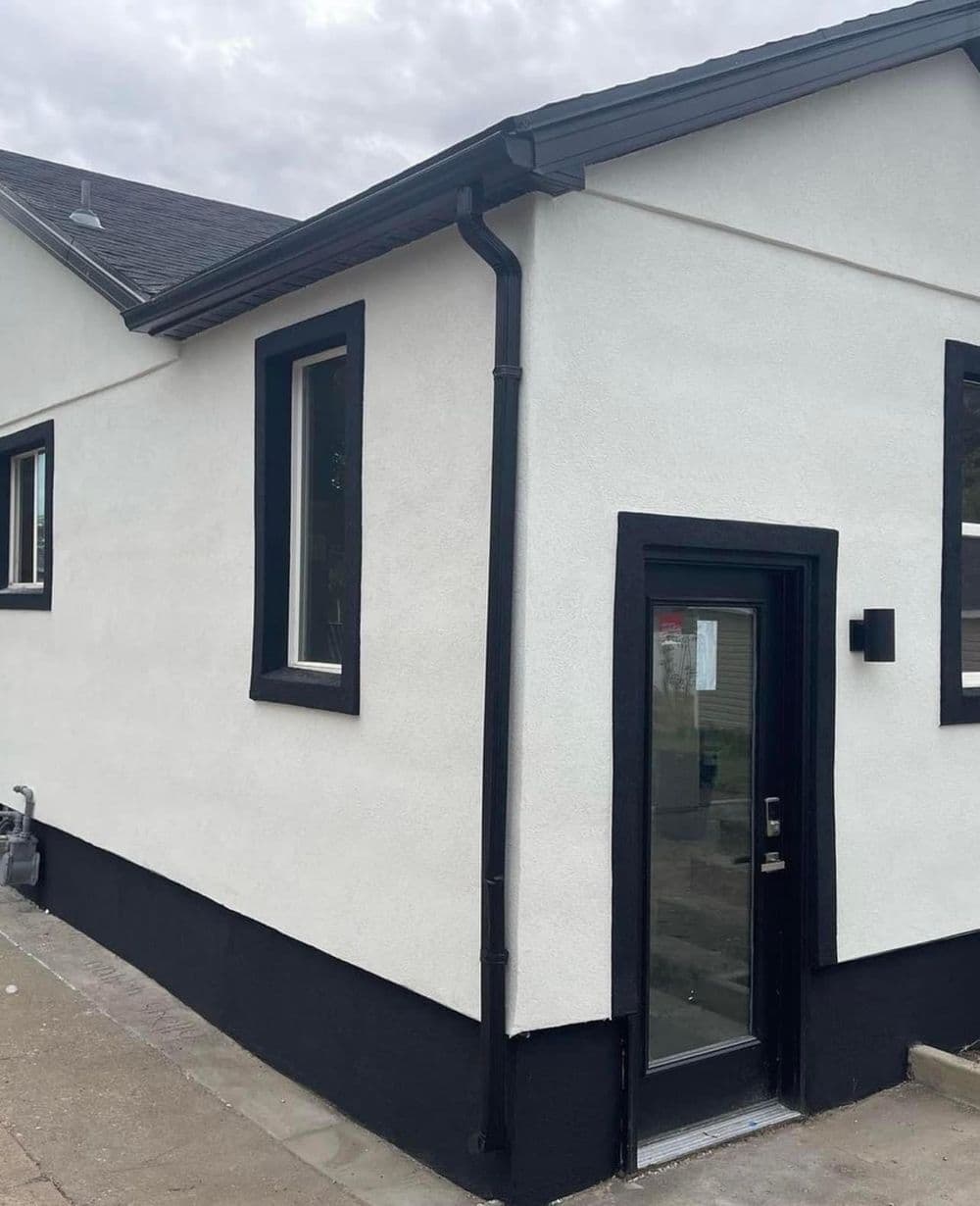 Modern home exterior with black trim and entrance, showcasing sleek design and clean lines.