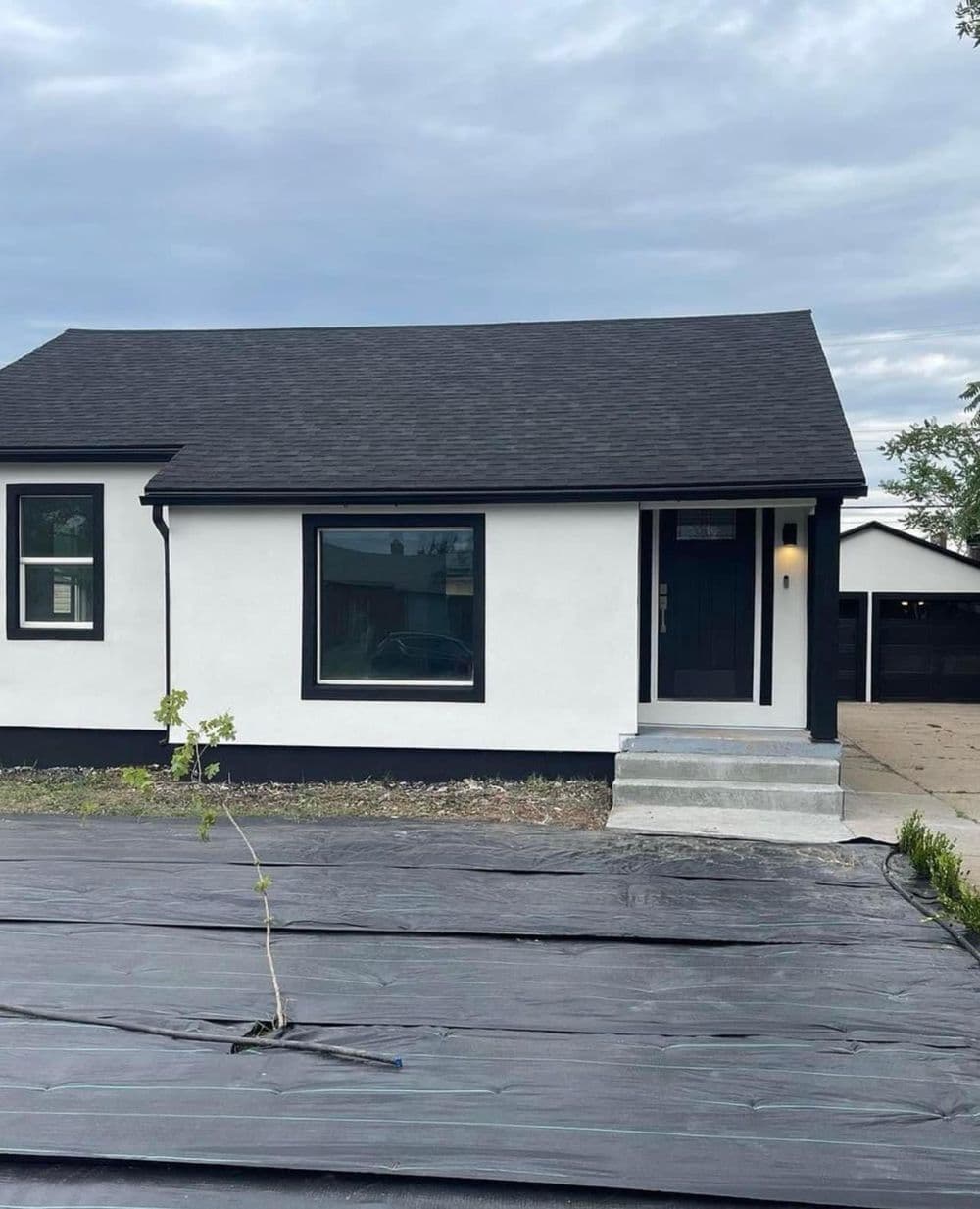 Modern black and white home with a landscaped front yard and new planting.